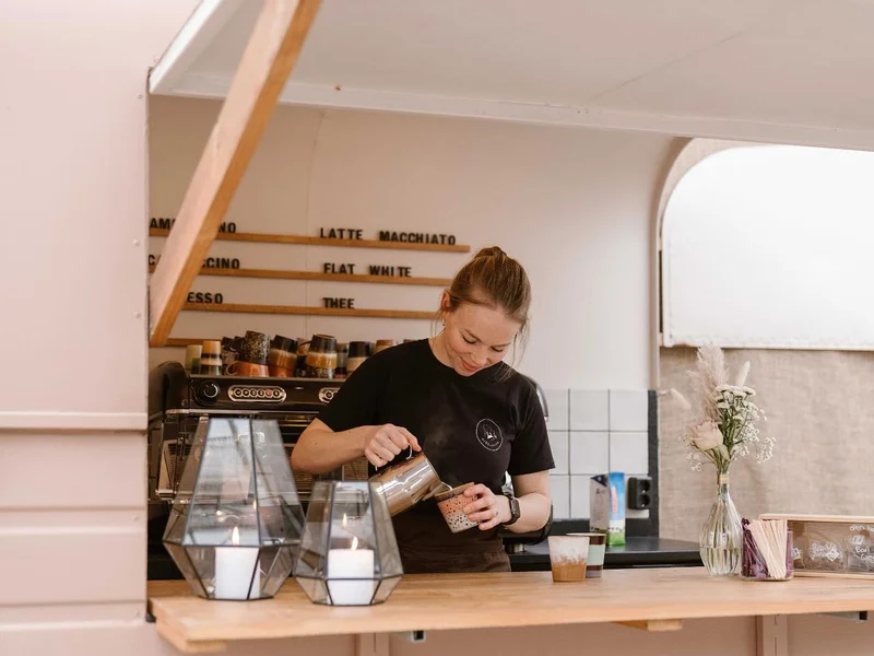 Barista maakt latte voor gasten