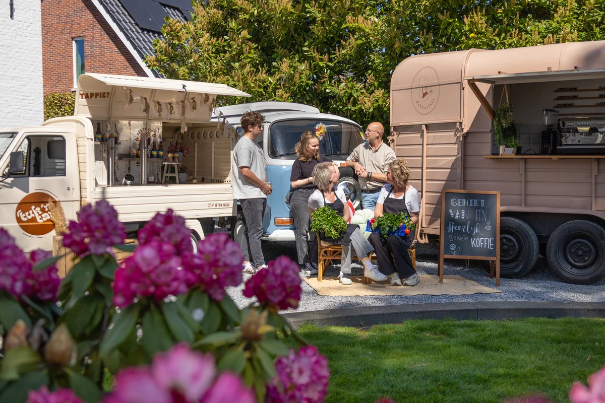 Sfeervolle opstelling van de Veluwsche Overvloed foodtrucks op een evenementlocatie