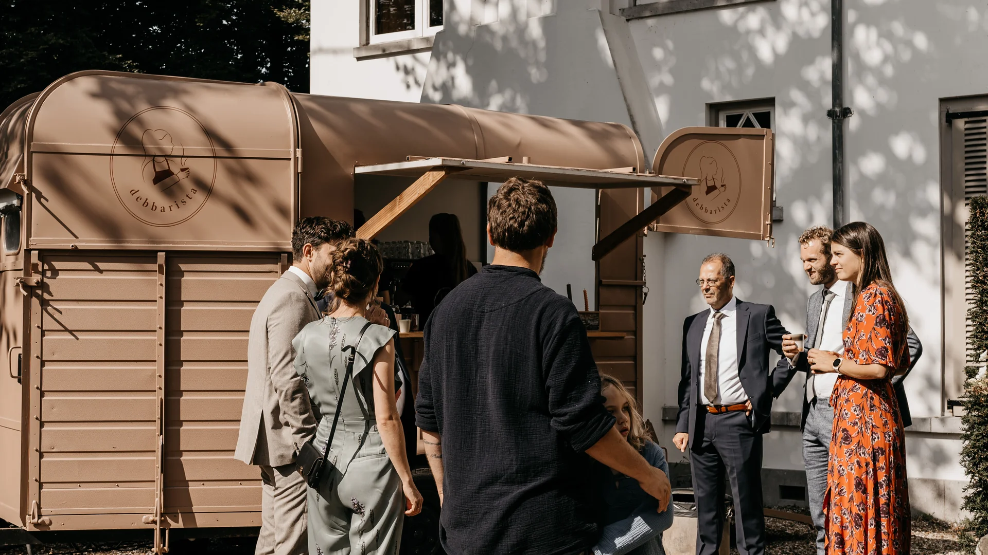 Gasten bestellen koffie bij de Debbarista koffietrailer tijdens een zakelijk event bij een witte villa